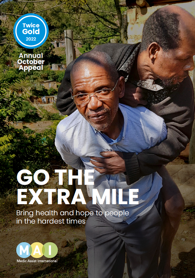 Twice Gold Annual October Appeal MAI - brochure cover. Pastor Leonard carries patient.