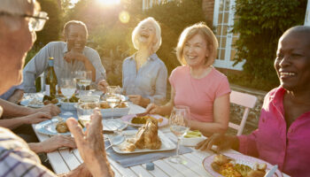 Group Of Senior Friends Enjoying Outdoor Dinner Party At Home Host a dinner party